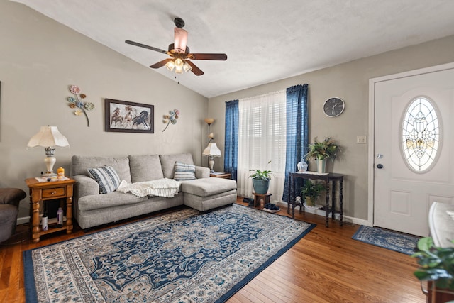 living area with vaulted ceiling, ceiling fan, wood finished floors, and baseboards