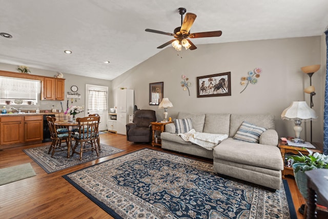 living area featuring a ceiling fan, vaulted ceiling, wood finished floors, and recessed lighting