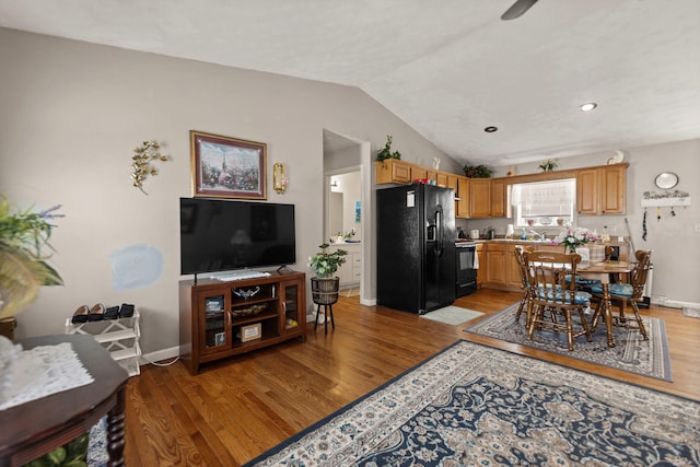 interior space featuring lofted ceiling, baseboards, and light wood finished floors