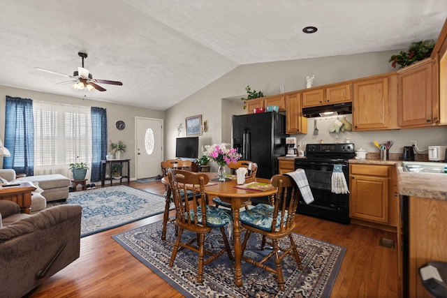 dining area featuring dark wood-style floors, lofted ceiling, and a ceiling fan