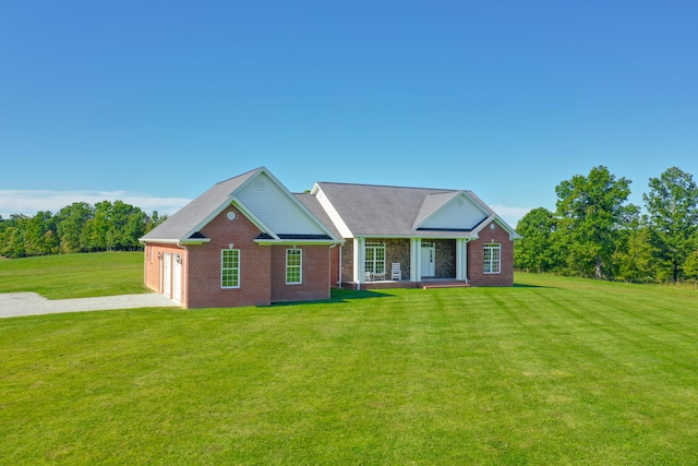 view of front of house featuring a garage, driveway, brick siding, and a front yard