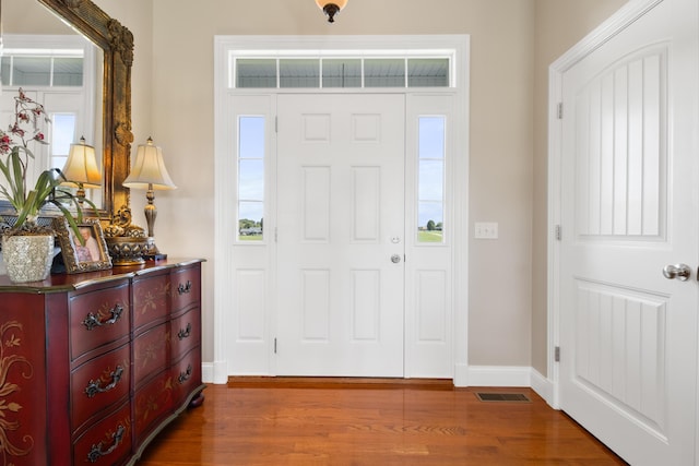 entrance foyer with dark wood-style flooring, visible vents, and baseboards