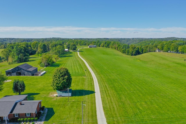 birds eye view of property with a view of trees and a rural view