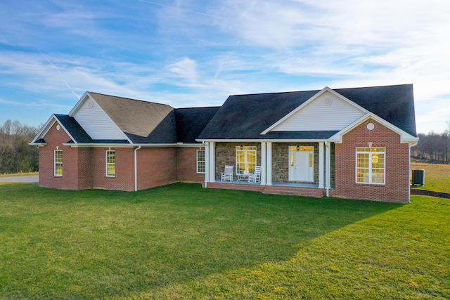 back of house featuring brick siding, a lawn, a porch, and central air condition unit