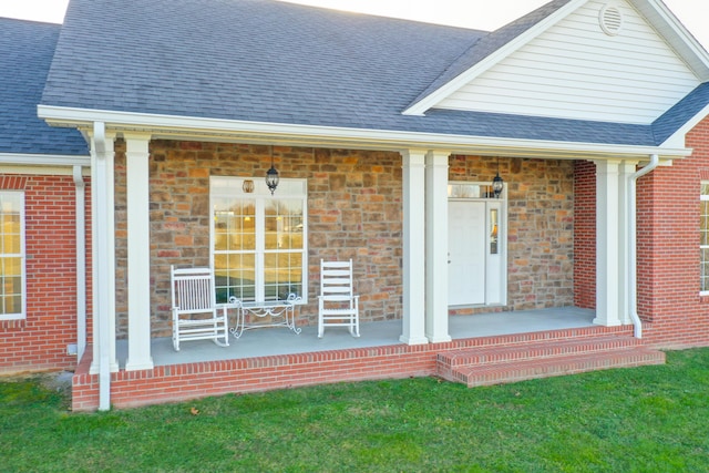 view of exterior entry featuring a porch, brick siding, and a shingled roof