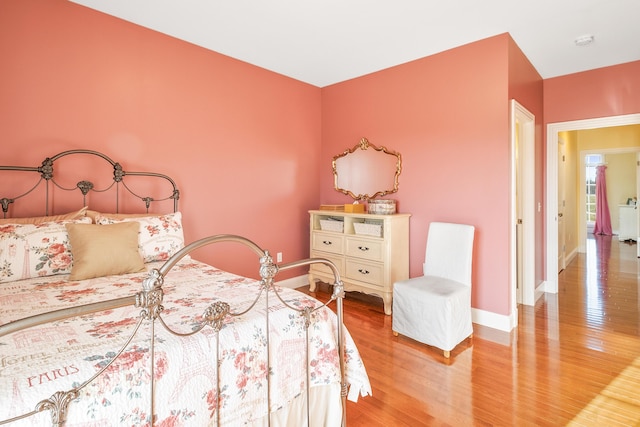 bedroom with light wood-type flooring and baseboards