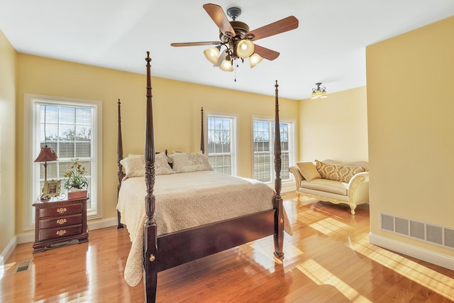 bedroom featuring visible vents, multiple windows, and light wood-style flooring