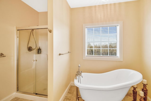 full bathroom featuring a soaking tub, a shower stall, and baseboards