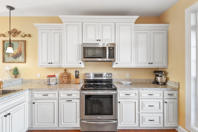 kitchen featuring appliances with stainless steel finishes, light countertops, and white cabinetry