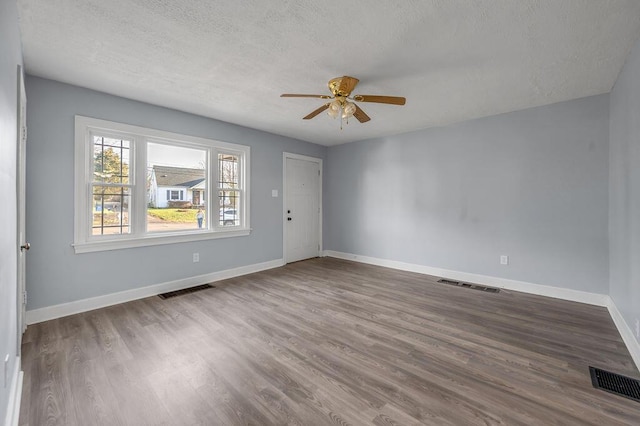 empty room with visible vents, baseboards, and wood finished floors