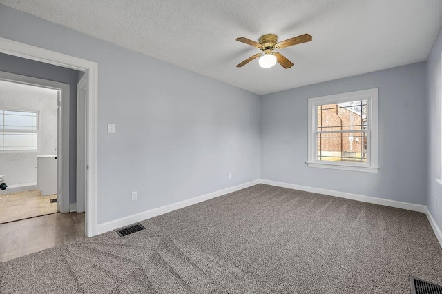 unfurnished room with carpet, baseboards, and visible vents