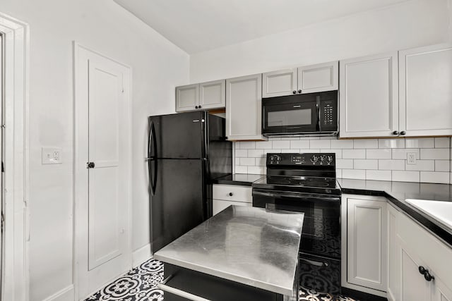 kitchen featuring dark countertops, black appliances, backsplash, and gray cabinetry