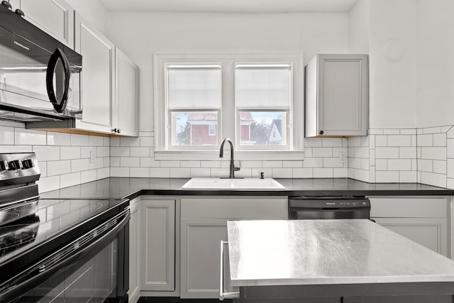 kitchen with black appliances, tasteful backsplash, gray cabinets, and a sink