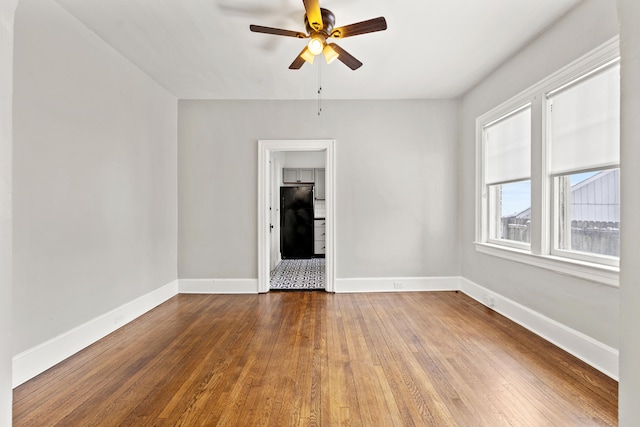 spare room with ceiling fan, baseboards, and wood finished floors