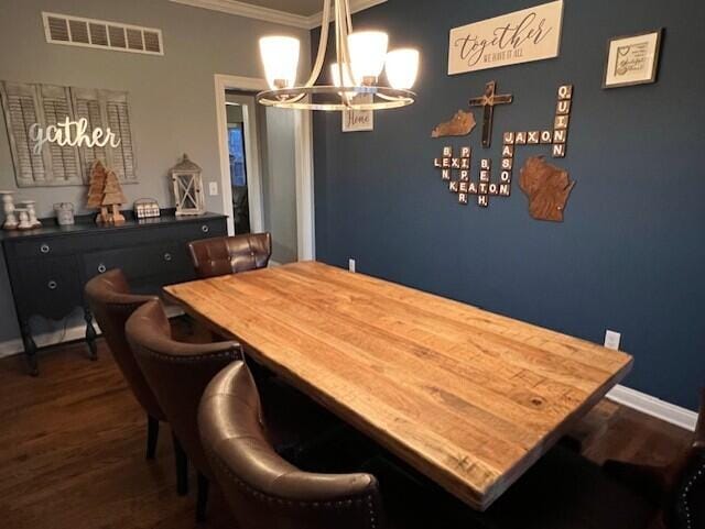 dining space featuring crown molding, dark wood finished floors, visible vents, an inviting chandelier, and baseboards