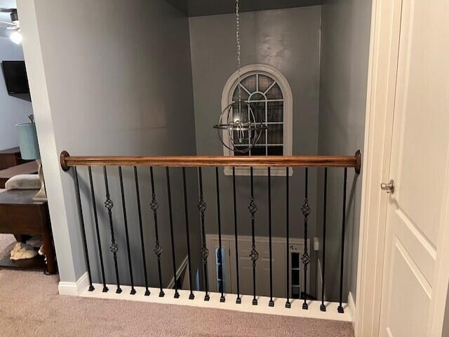 stairway featuring a notable chandelier and carpet flooring