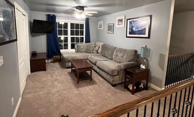 carpeted living room featuring ceiling fan and baseboards