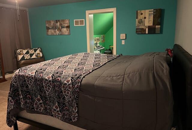 carpeted bedroom featuring visible vents