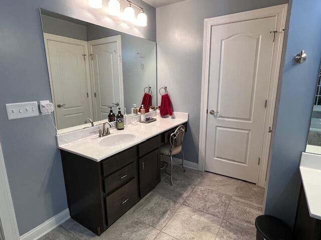 full bathroom with vanity and baseboards