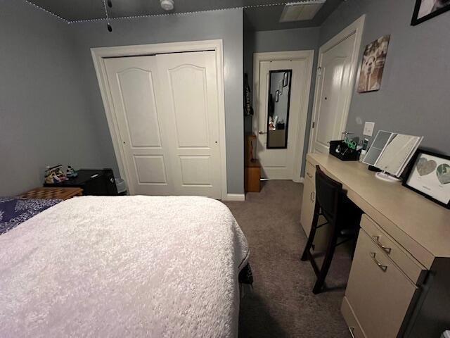 carpeted bedroom with a closet and baseboards