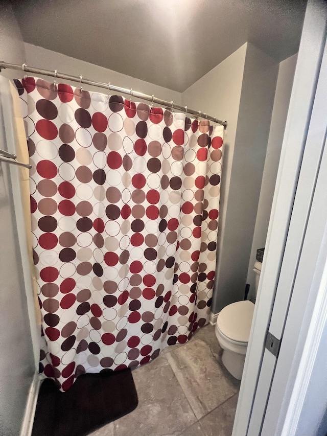 bathroom featuring a shower with shower curtain and toilet