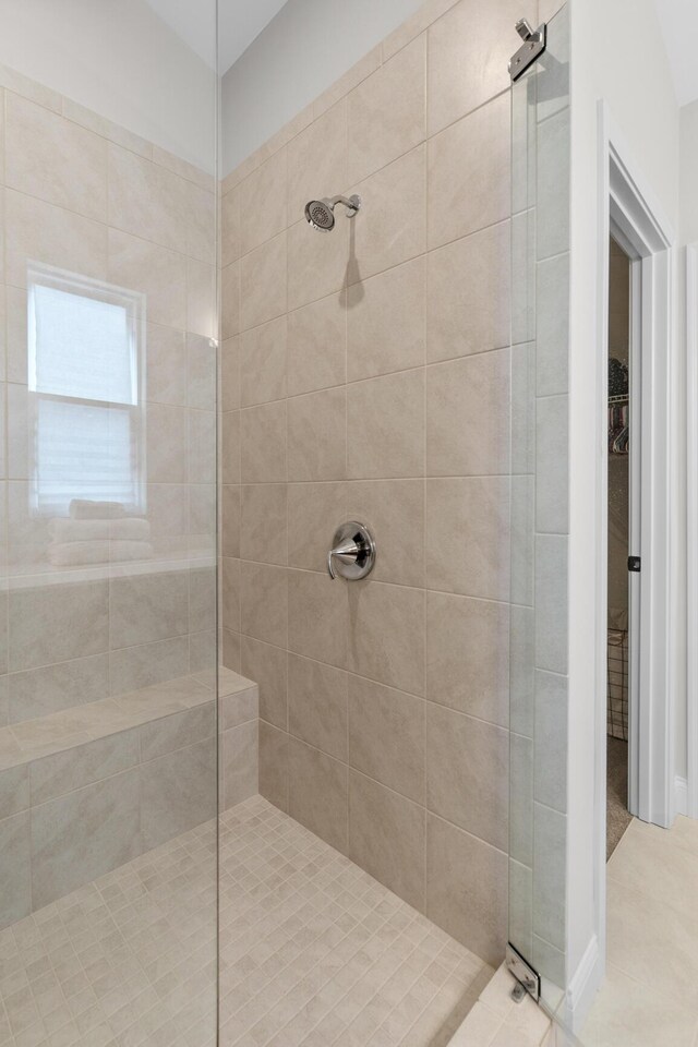 ensuite bathroom with tile patterned flooring, a sink, a shower stall, double vanity, and ensuite bath