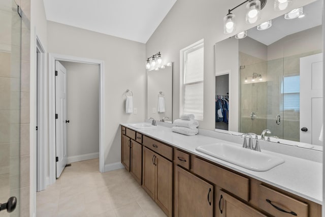 full bathroom with tile patterned floors, double vanity, a sink, and a stall shower