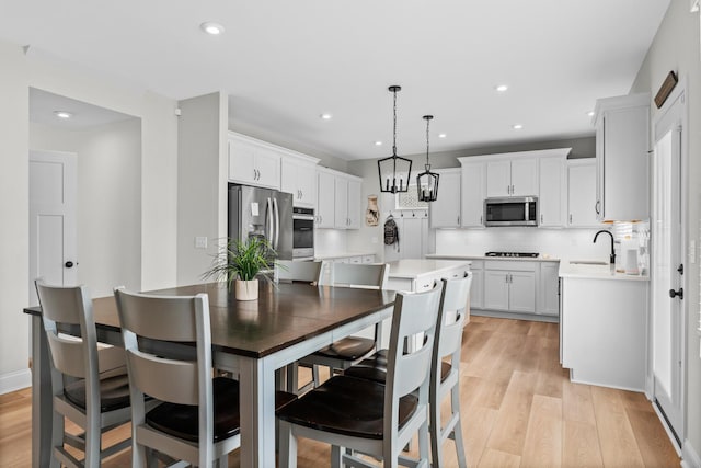dining room featuring recessed lighting, a notable chandelier, and light wood-style flooring