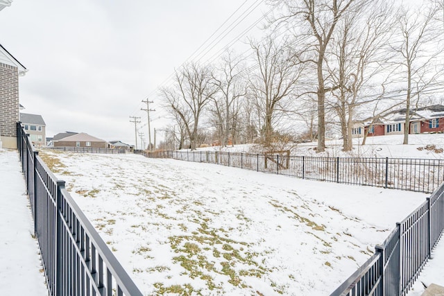 yard covered in snow featuring a residential view and fence