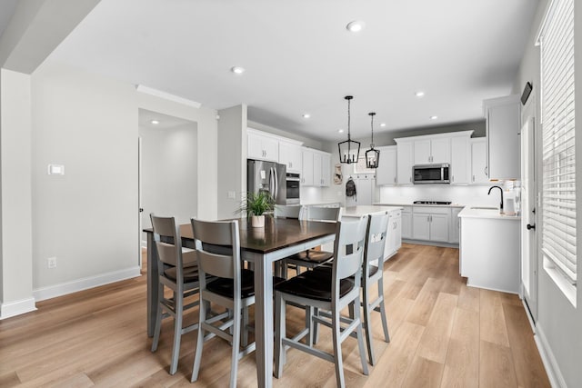 dining area with baseboards, light wood finished floors, plenty of natural light, and recessed lighting