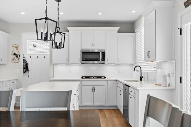 kitchen with tasteful backsplash, an inviting chandelier, a sink, and stainless steel appliances