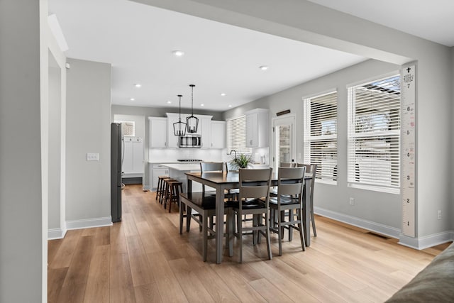 dining space with recessed lighting, light wood finished floors, visible vents, and baseboards