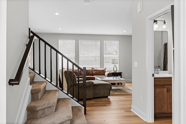 living room featuring light wood-style flooring, stairway, recessed lighting, and baseboards