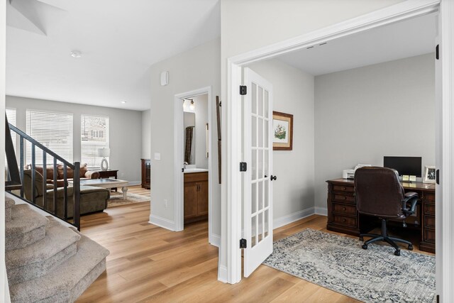 office area with french doors, light wood-type flooring, and baseboards