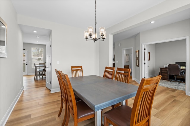 dining space featuring baseboards, light wood finished floors, an inviting chandelier, and recessed lighting