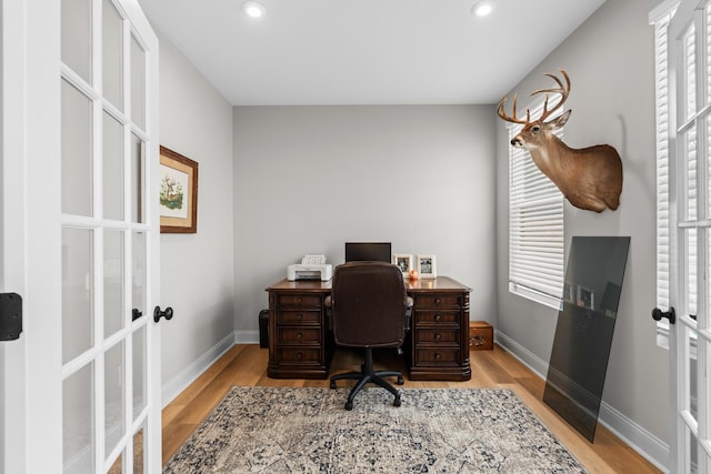 office space featuring a wealth of natural light, light wood-style floors, and french doors