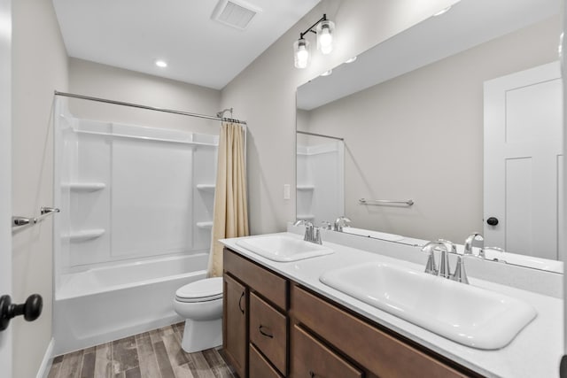 bathroom featuring shower / tub combo, visible vents, a sink, and wood finished floors