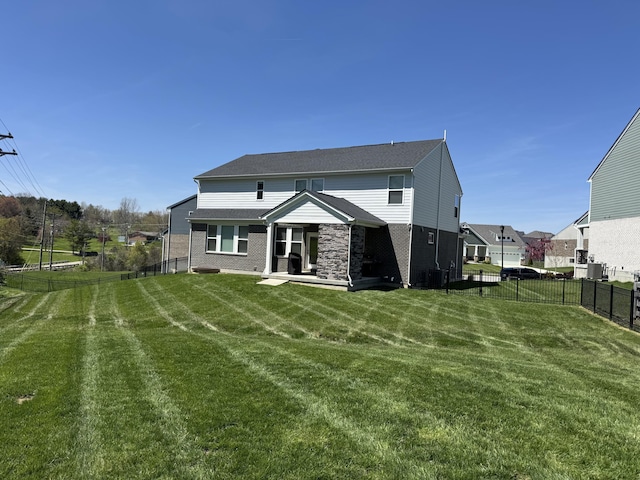 rear view of property with a yard, a fenced backyard, and brick siding