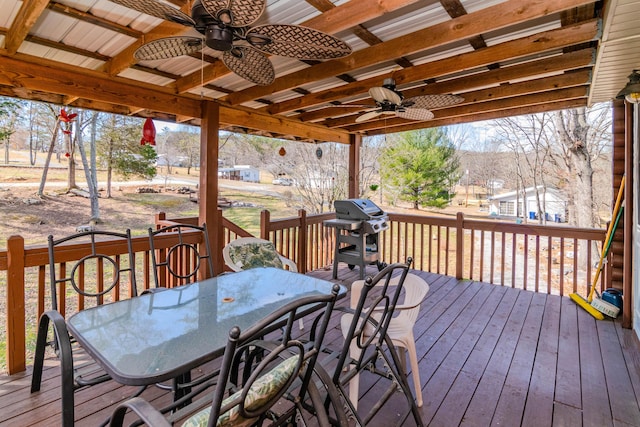 wooden terrace with a ceiling fan, outdoor dining area, and area for grilling