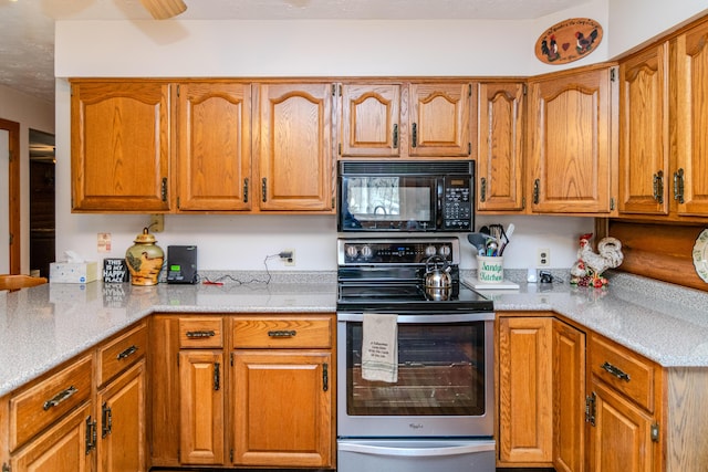 kitchen with stainless steel electric range oven, black microwave, and brown cabinetry