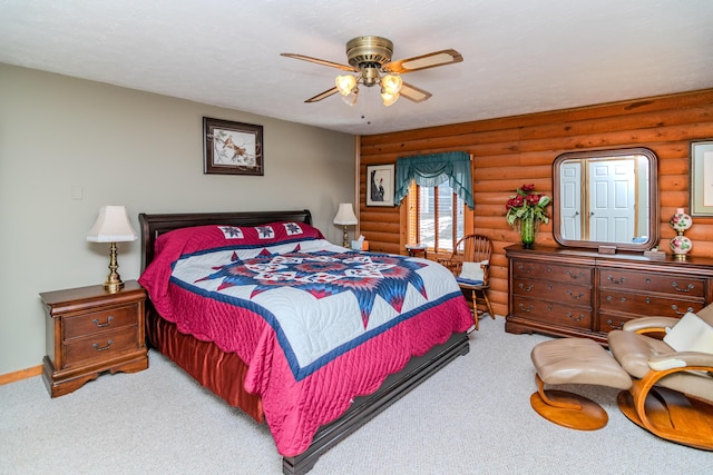 bedroom featuring carpet floors, ceiling fan, and log walls