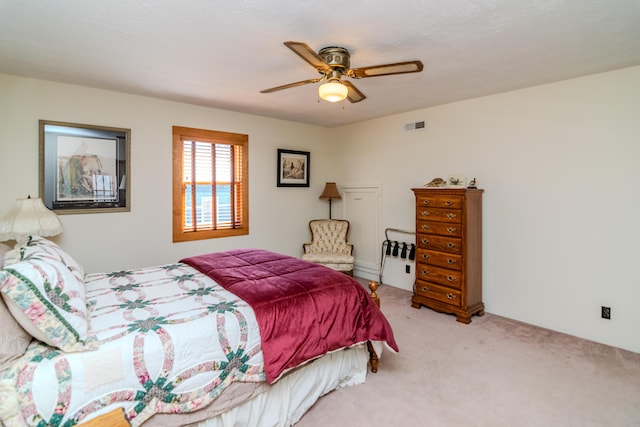 carpeted bedroom with visible vents and a ceiling fan