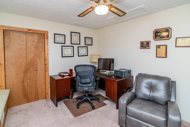 home office featuring carpet, attic access, and a ceiling fan