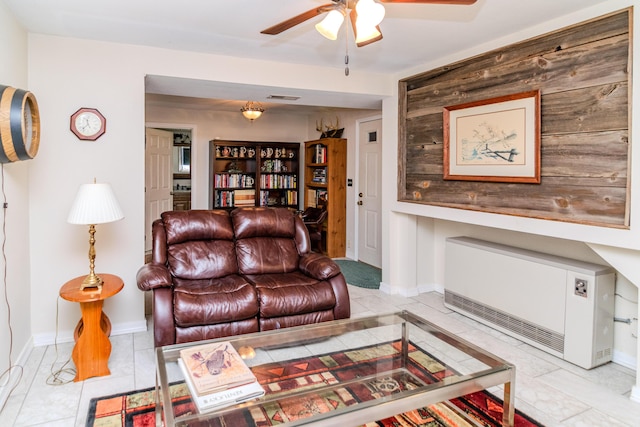 living room featuring a ceiling fan, heating unit, visible vents, and baseboards