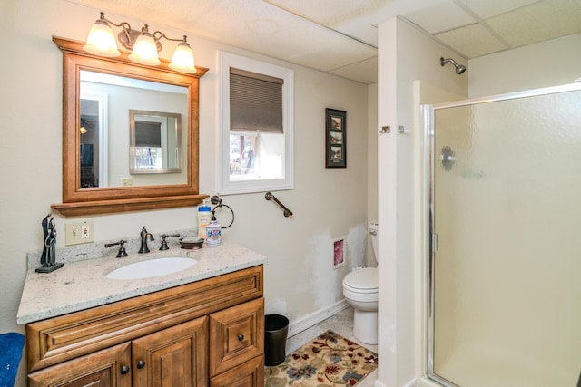 full bath featuring a drop ceiling, a shower stall, toilet, and vanity