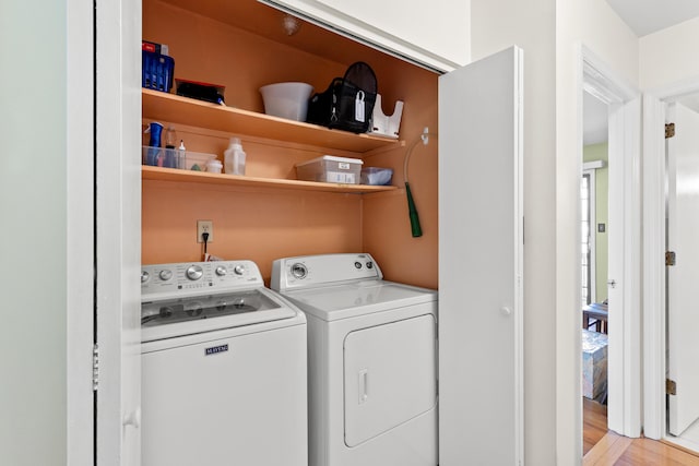 washroom with laundry area, light wood-style flooring, and separate washer and dryer