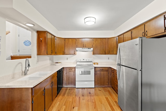 kitchen with black dishwasher, white range with electric stovetop, freestanding refrigerator, under cabinet range hood, and a sink