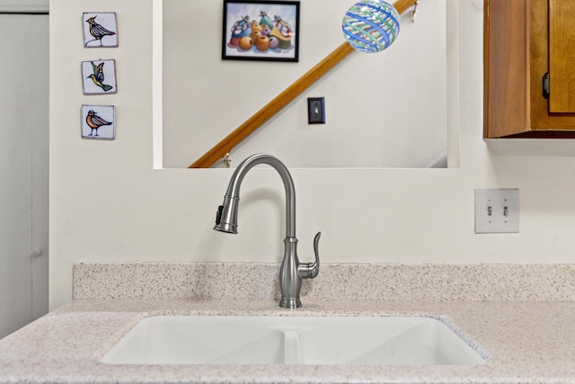 details with light stone counters, brown cabinetry, and a sink