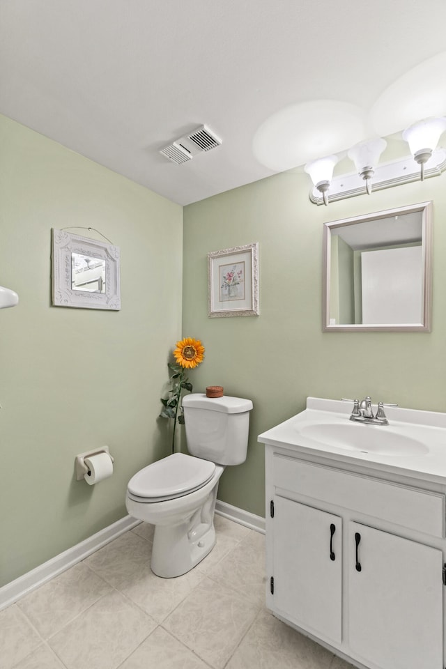 bathroom featuring visible vents, toilet, vanity, baseboards, and tile patterned floors