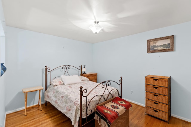 bedroom featuring wood finished floors and baseboards